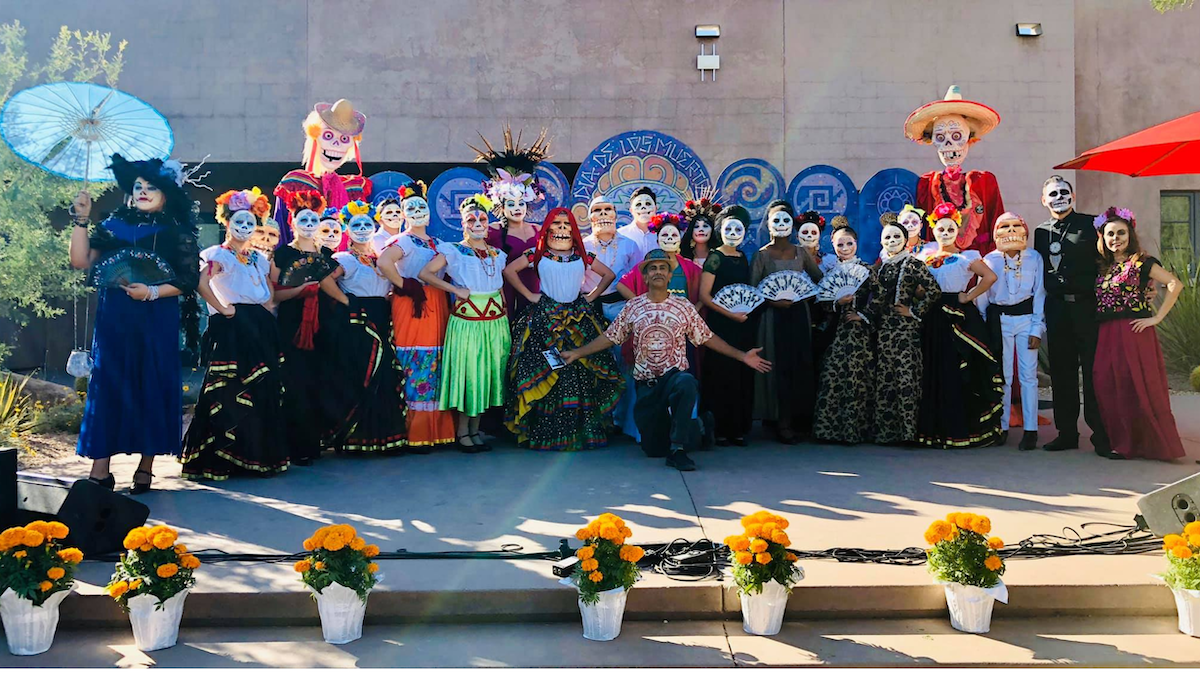 Zarco in front of a group of folklorico dancers wearing his masks